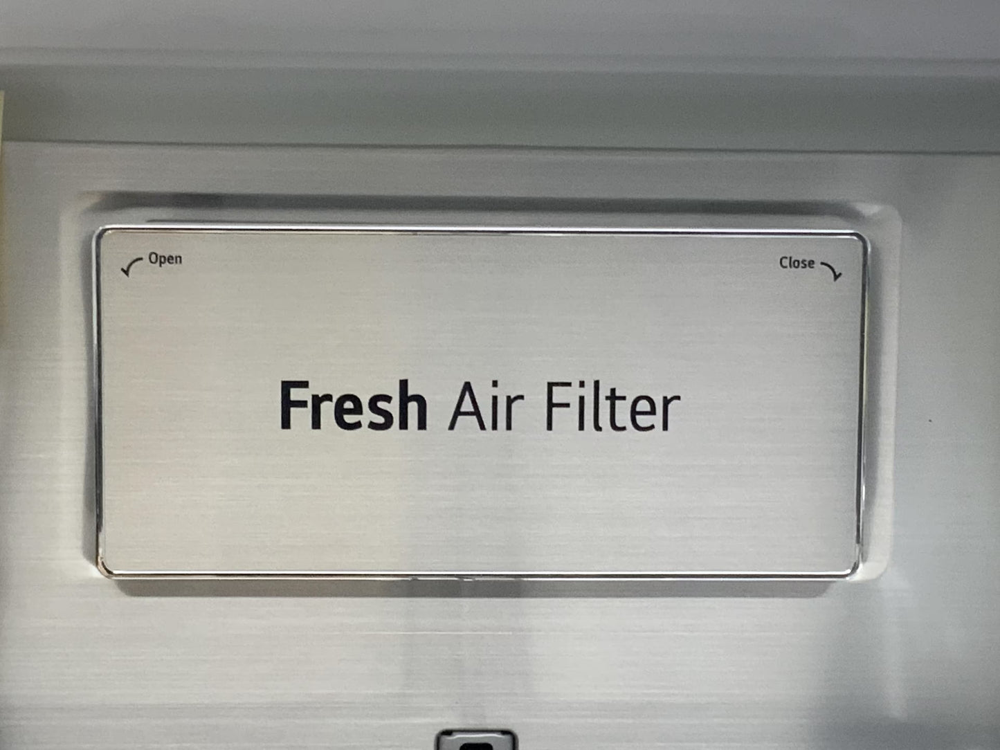 Metallic 'Fresh Air Filter' switch on a silver background of LG Fridge